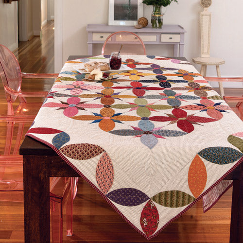 Scrappy Alabama Beauty block quilt draped over table