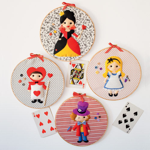 Styled shot of four appliqué embroidery hoop art with alice, queen, mad hatter and playing card soldier