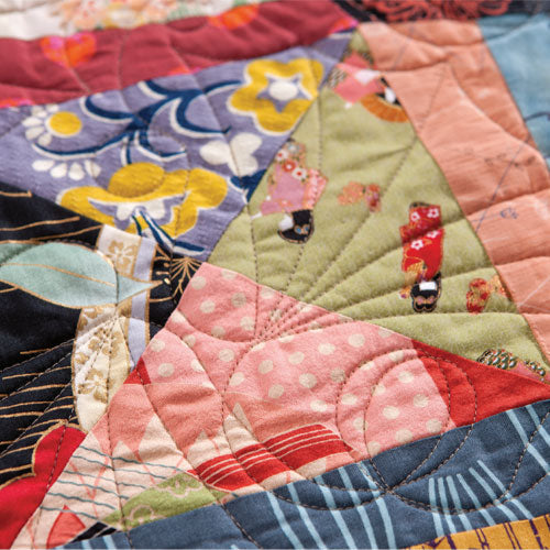 Detailed closeup of oriental fabrics patchwork and swirl quilt pattern