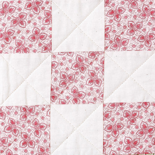 Closeup of pink and white nine patch quilt block