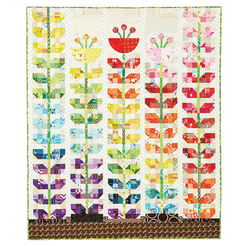 Flat shot of patchwork and appliqué sprouting flowers quilt