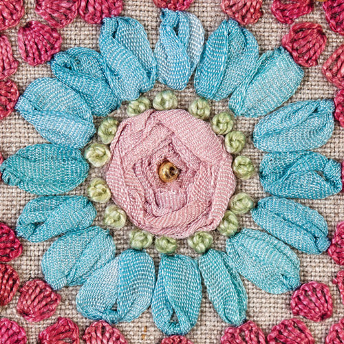 Closeup of blue and pink ribbon embroidery flower design