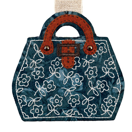 Flat shot of rounded blue luggage with white embroidered flowers