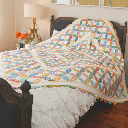 Styled shot of appliqué orange peel quilt on bed