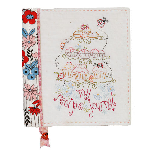 Flat shot of front cover of embroidered recipe jornal