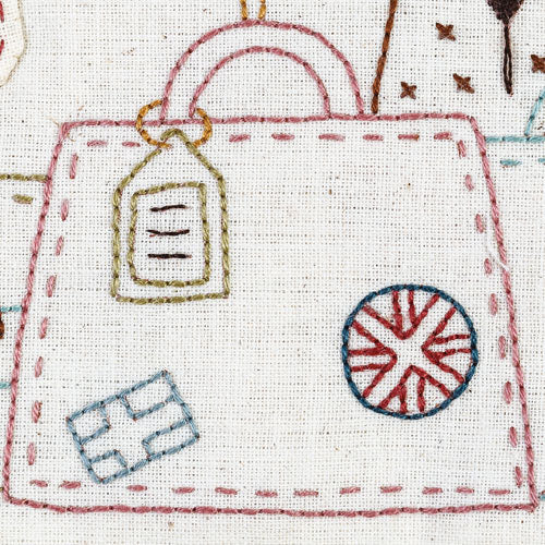 Detailed closeup of embroidered luggage with flag stamps
