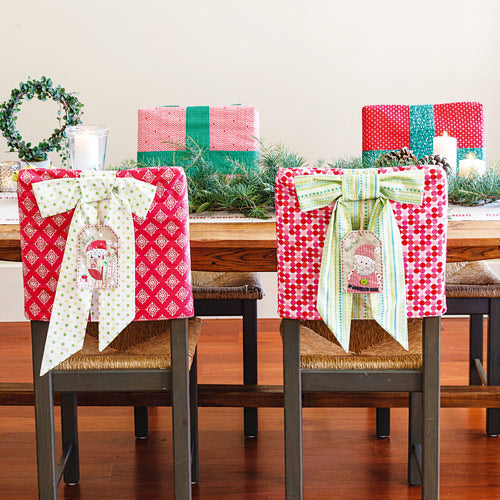 Styled shot of Christmas gift chair covers with appliqué and embroidered tags