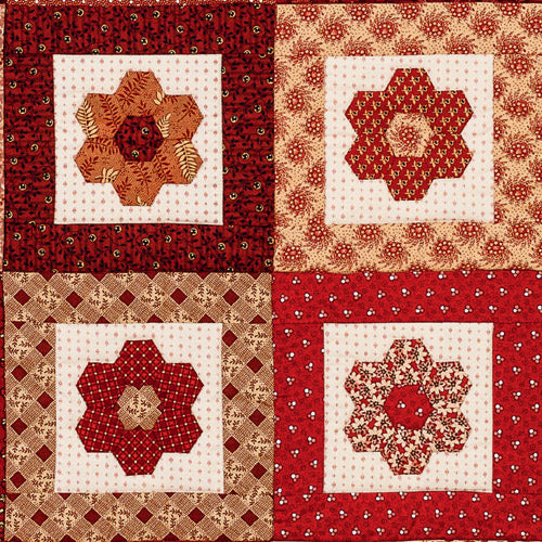 Closeup of four blocks from english paper pieced hexagon flower quilt