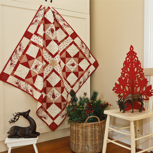 Styled shot of appliqué and embroiodered angel christmas quilt hanging up