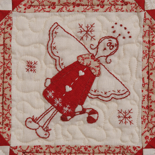 Closeup of appliqué and embroidered angel from appliqué and embroiodered angel christmas quilt
