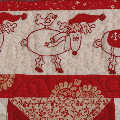 Closeup of embroidered reindeer from appliqué and embroiodered angel christmas quilt
