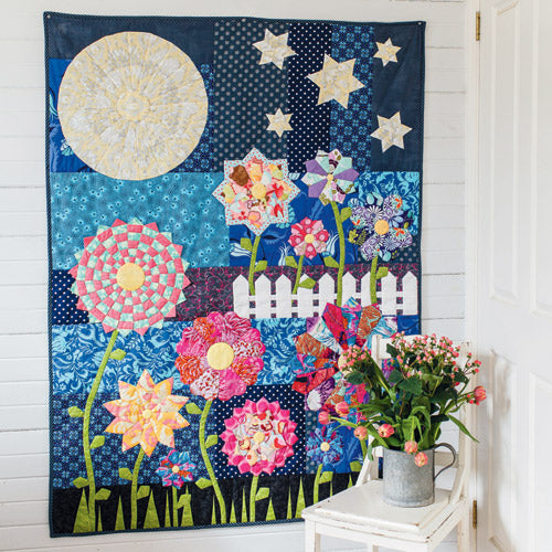 Styled shot of night garden appliqué flower quilt hanging up