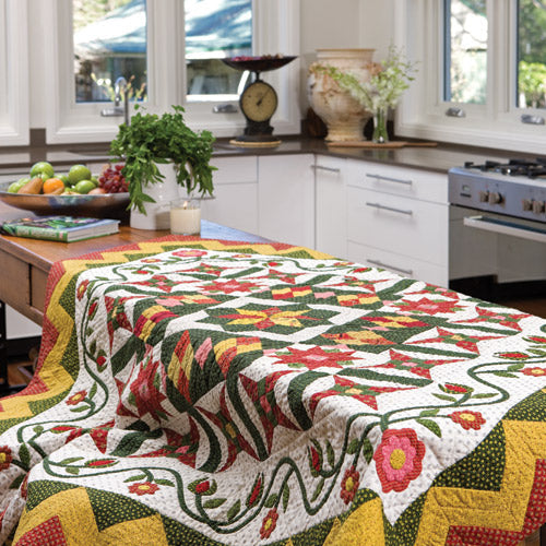 Styled shot of patchwork and appliqué quilt on table
