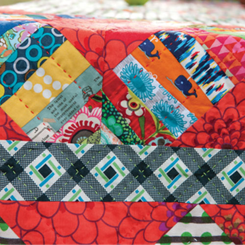 Detailed closeup of string pieced boarder with hand quilting