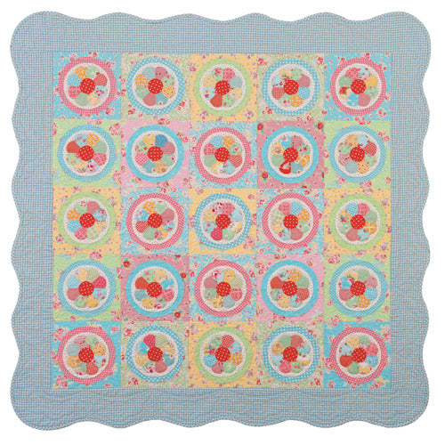 Flat shot of appliqué flower and patchwork quilt
