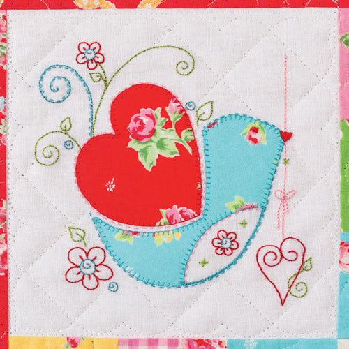 Closeup of appliqué and embroidered bird with embroidered flowers from appliqué and embroidered bird patchwork quilt