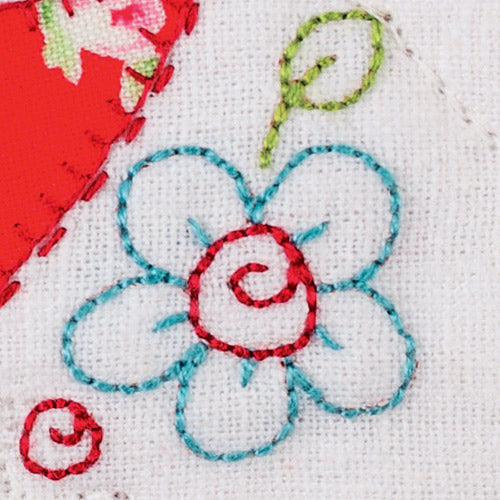 Closeup of embroidered flower from appliqué and embroidered bird patchwork quilt