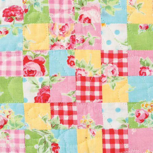 Closeup of patchwork squares from appliqué and embroidered bird patchwork quilt