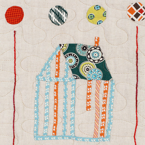Closeup of appliqué house and circles from vintage appliqué sampler quilt