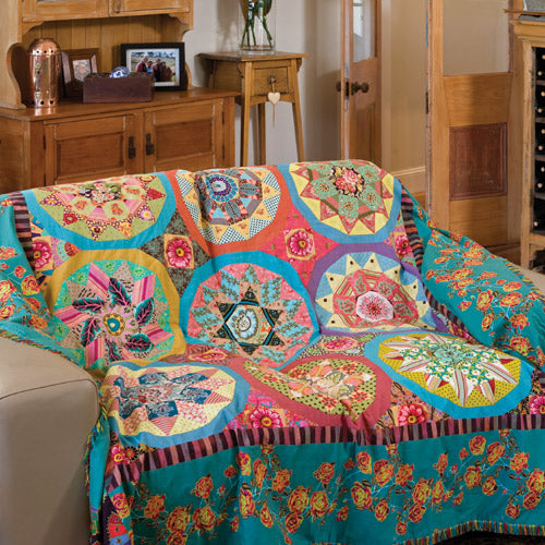Styled shot of english paper pieced star coverlet quilt draped over couch