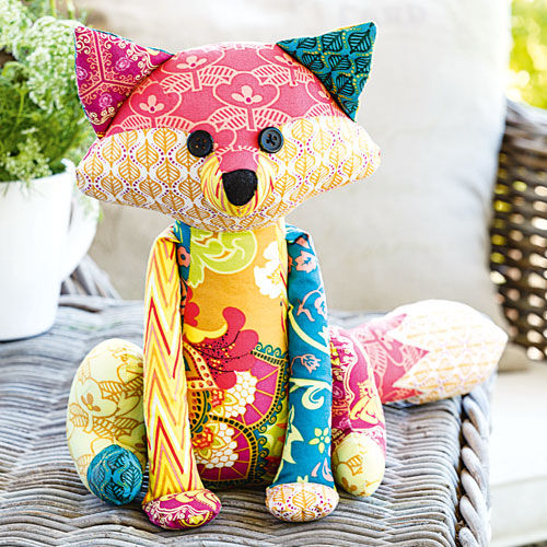 Styled shot of patchwork fox soft toy sitting ourside on table