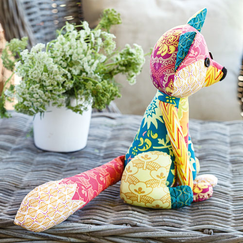 Side shot of bright patchwork fox soft toy outside