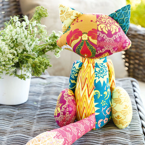 Back shot of bright patchwork fox soft toy outside