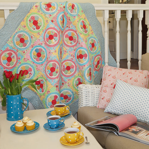 Styled shot of english paper pieced vintage dresden plate quilt hanging up