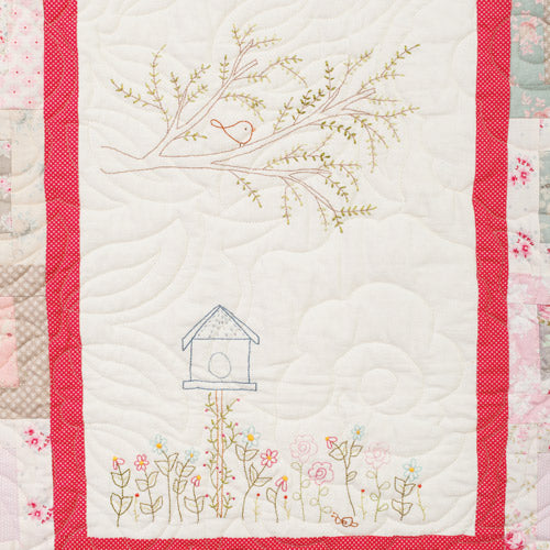 Closeup of embroidery panel with embroidered garden design from pretty embroidered patchwork quilt