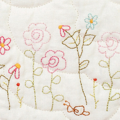 Closeup of embroidered flowers from pretty embroidered patchwork quilt