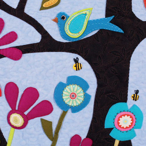 Closeup of appliqué, bird, bees and flowers from appliqué owl, bird, flower and tree quilt