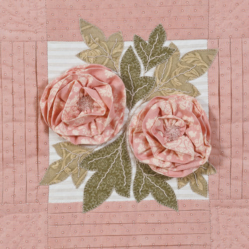 Closeup of 3d fabric flowers and appliqué leaves with pleased border