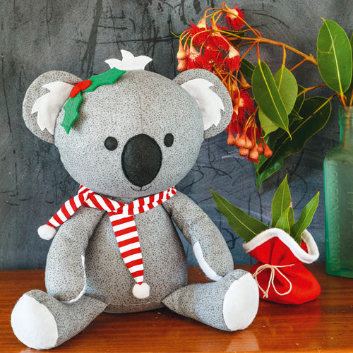 Styled shot of Christmas koala softie toy with santa sack of gumleaves