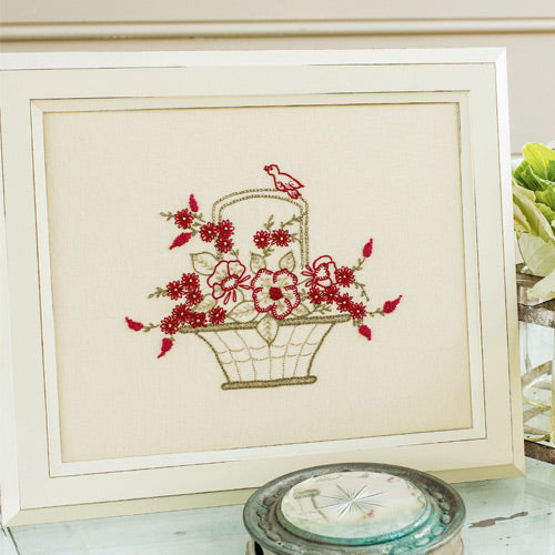 Styled shot of framed bird and flowers in basket embroidery