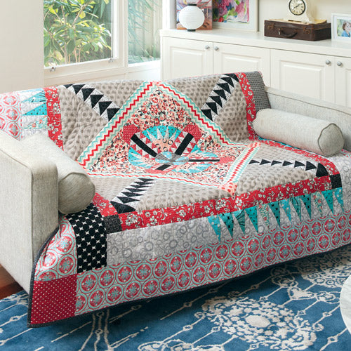 Medallion quilt in red and aqua draped over couch