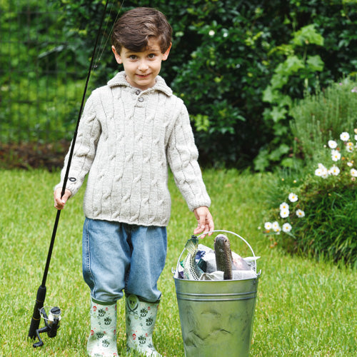 Styled shot of boy wearing cable knit jumpet with fishing gear