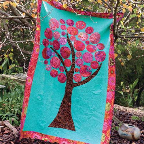 Bright modern, abstract tree quilt with circles, styled on tree