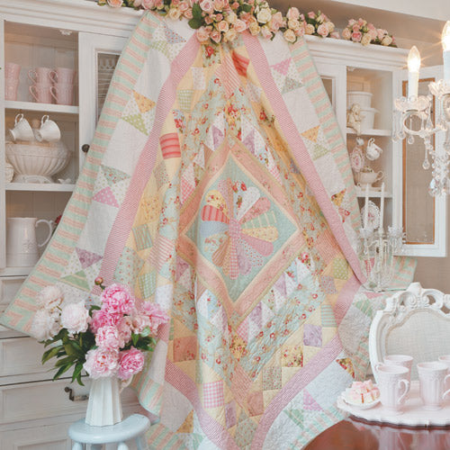 Styled shot of english paper pieced and patchwork medallion quilt hanging up