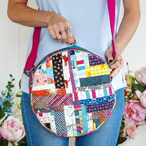 Styled shot of woman zipping round scrappy patchwork bag