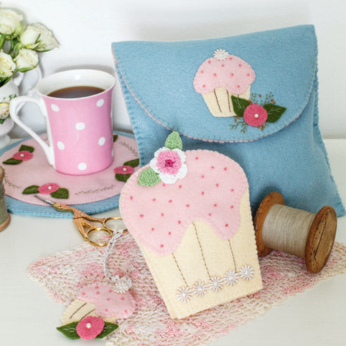 Styled shot of cupcake themed sewing accessories with vintage spools