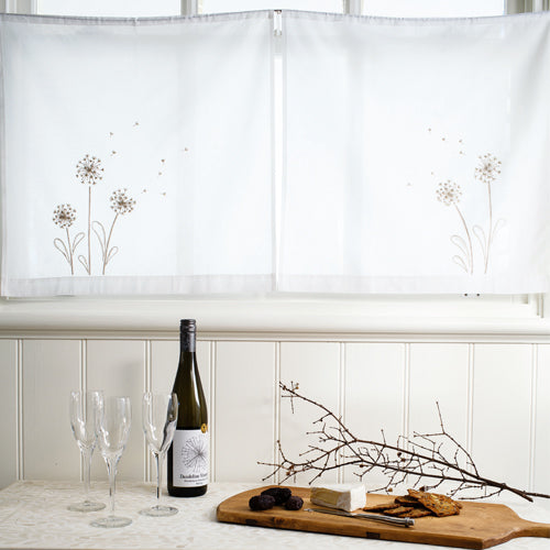 Styled shot of dandelion embroidered curtains at a window