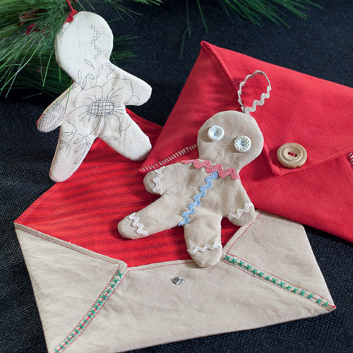 Styled shot of gingerbread dollygram gift tags and envelopes