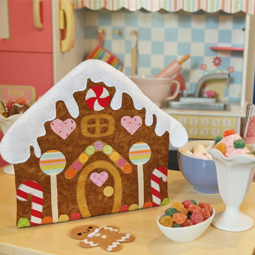 Styled shot of outside of gingerbread house from gingerbread playset with gingerbread man doll
