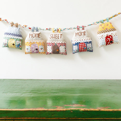Styled shot of 3D appliqué and embroidered home sweet home house bunting