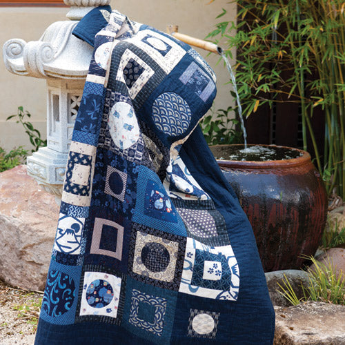 Styled shot of appliqué and patchwork japanese style quilt in japanese garden