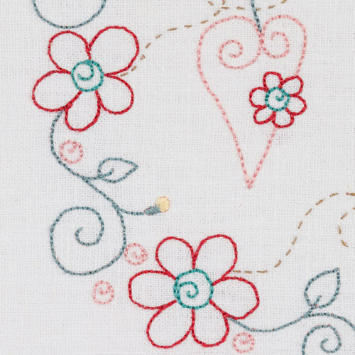 Detailed closeup of embroidered heart and flowers on vines