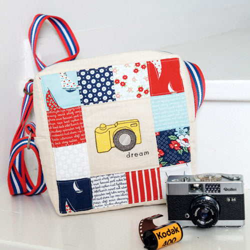 Styled shot of square bag with patchwork, camera appliqué and embroidery with old camera