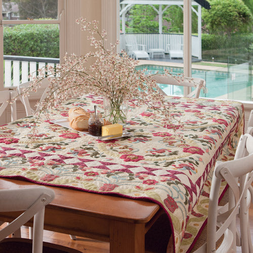 Styled shot of traditional flower appliqué quilt over dining table