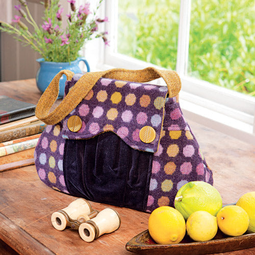 Styled shot of retro style handbag made in purple spot wool fabric