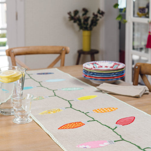 Styled shot of Christmas lights table runner on table
